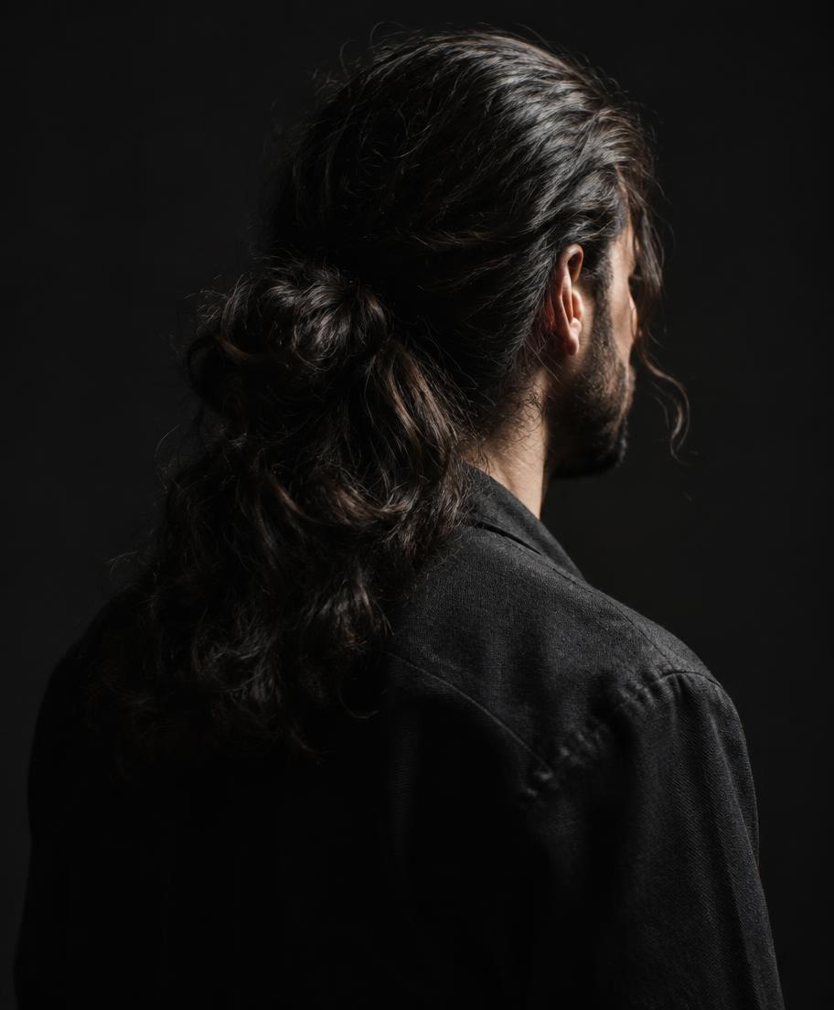 Long dark men's hair tied back, seen from behind